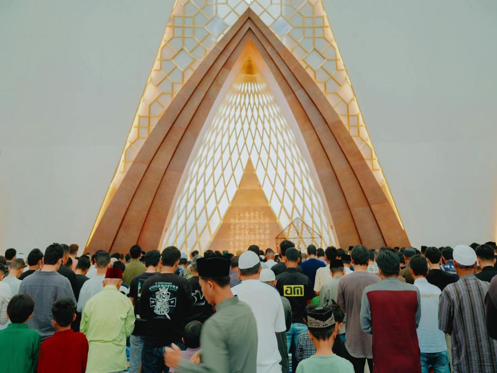 muslims praying in modern architectural mosque